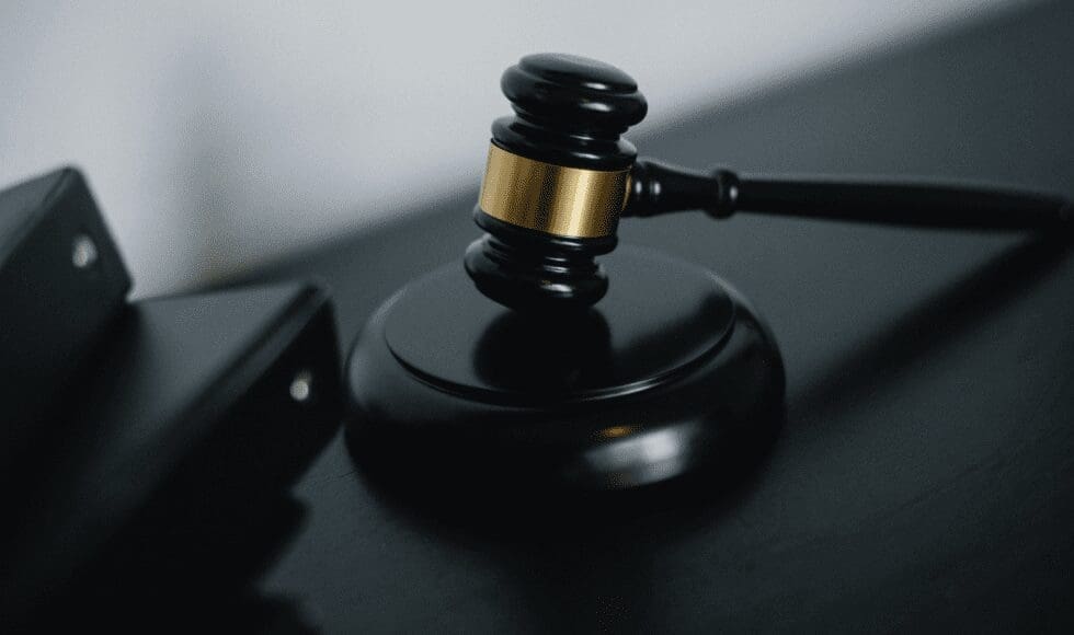 A judge's gavel resting on a sound block.