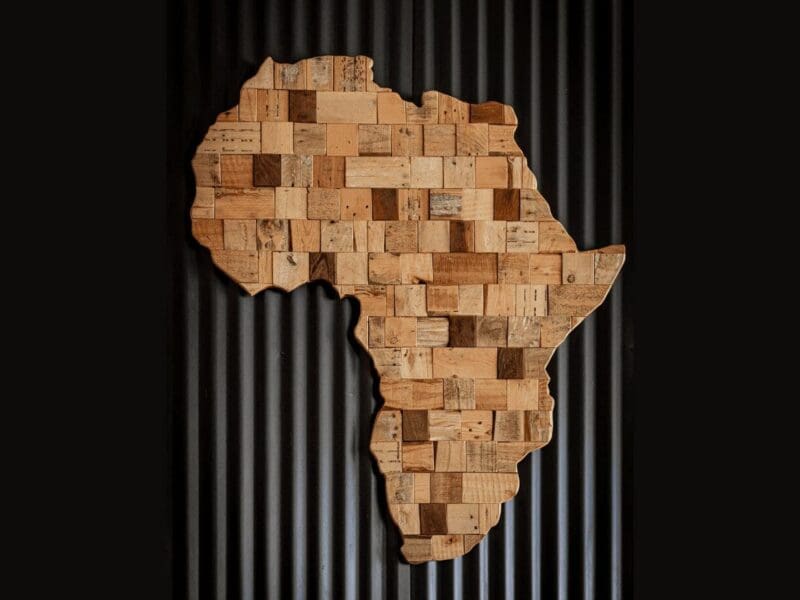 Wooden art piece shaped like the African continent on a dark background. Wooden art piece shaped like the African continent on a dark background.