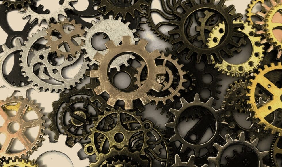 Close-up of interlocking metal gears in various shapes and sizes.